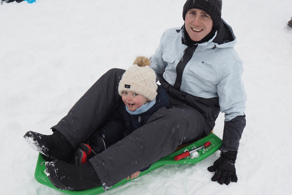 Family skiing in Valmorel: Enjoying sledging down the slopes